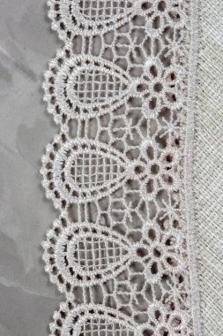 Gri beton arka planda bir fabrika dantelinin yakın çekimi.