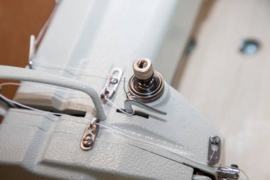 Onarım ve bakım sırasında bir tarafa eğilmiş endüstriyel dikiş makinesinin parçaları ve bileşenleri