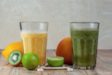 İki büyük bardak kivi ve ahşap bir masada meyvelerle çevrili ıspanaklı içecek. Kilo verme ve düzgün beslenme kavramı