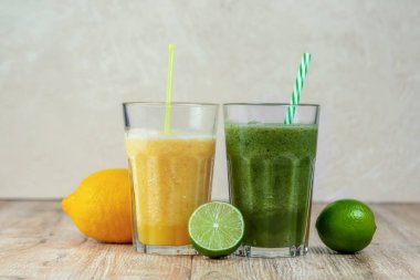 İki büyük bardak kivi ve ahşap bir masada meyvelerle çevrili ıspanaklı içecek. Kilo verme ve düzgün beslenme kavramı