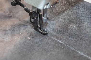 Dikiş makinesi ayak ve iğne yakın çekim kumaş, dikiş işlemi yapar