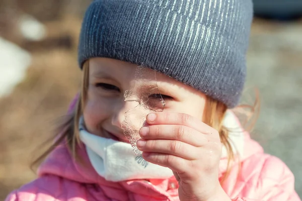 Kleines Kaukasisches Mädchen Hält Ein Stück Transparentes Eis Vor Ihr — Stockfoto