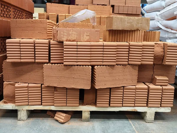 Pallet with red bricks in a large building materials store, construction concept