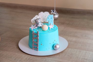 Açık mavi ayna jöleli küçük bir çocuk için doğum günü pastası. Çikolata dekoru ve bir numara.