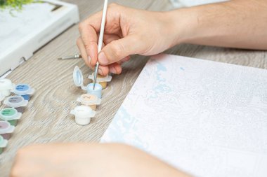 Yakından çekmek için fırça tutan bir adam. Yeni başlayanlar için resim. Yakın plan, seçici odaklanma..