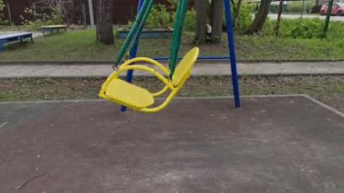 Boş bebek salıncağı parkta sallanıyor.