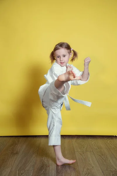 Kimonolu Kafkas Kız 'ın portresi. Evde sarı arka planda karate yapıyor.