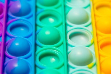 Duyusal oyuncağın yakın görüntüsünü gökkuşağı rengiyle kapat. Çocuklar ve yetişkinler için renkli anti-stres sensörleri oyuncağı..