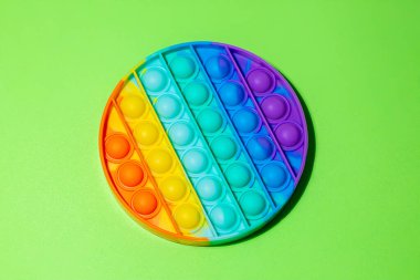 Silikon duyusal oyuncağın üst görüntüsü açık yeşil arka planda metin için kopyalama alanı ile birlikte. Çocuklar ve yetişkinler için anti-stres oyuncağı.