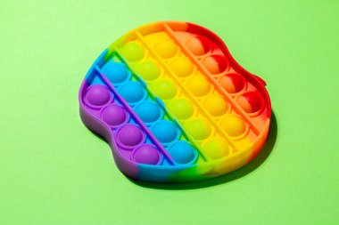 Silikon duyusal oyuncağın üst görüntüsü açık yeşil arka planda metin için kopyalama alanı ile birlikte. Çocuklar ve yetişkinler için anti-stres oyuncağı.