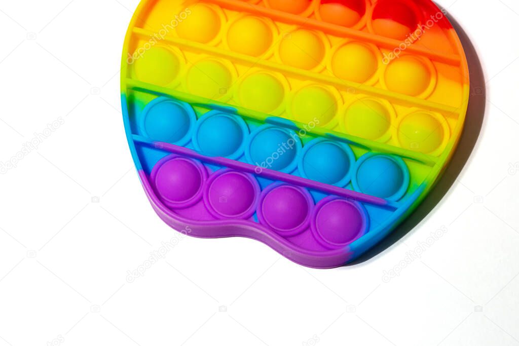 Close up view of the sensory toy pop it on white background.Rainbow color.Good as banner with copy space.Antistress toy for children and adult.