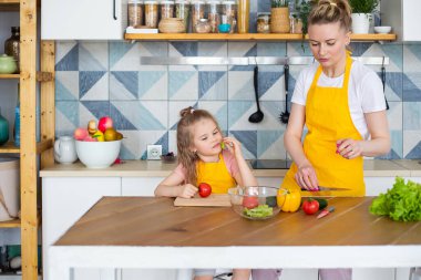 Çocuk, ebeveyninin rehberliğinde yemek yapmayı öğrenir..