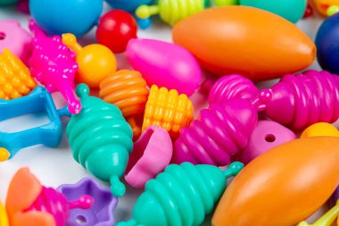 Çocukların yaratıcılığı için boncukların makro görünümü, beyaz arka planda bilezikler, kolyeler ve yüzükler yapabilirsiniz