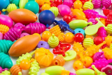 Çocukların yaratıcılığı için boncuklar, beyaz arka planda bilezikler, kolyeler ve yüzükler yapabilirsiniz.