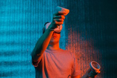 25-30 yaşlarında, sanal gerçeklik kulaklığı kullanan genç beyaz bir adam. VR, gelecek, cihazlar, neon ışıkta teknoloji kavramı.