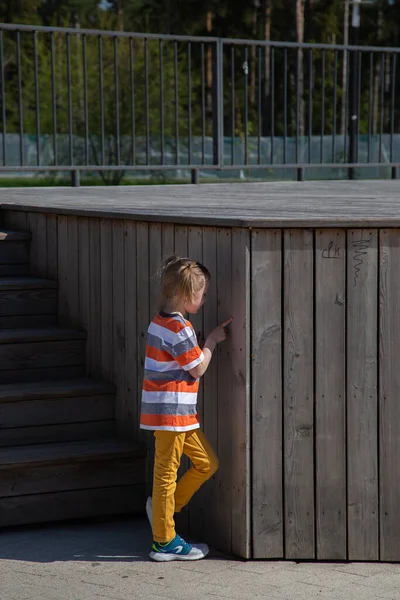 Vit liten flicka går genom territoriet av lekplatsen utomhus — Stockfoto