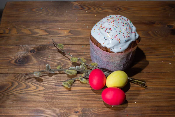 Традиційний великодній торт і барвисті великодні яйця на дерев'яному фоні . — стокове фото