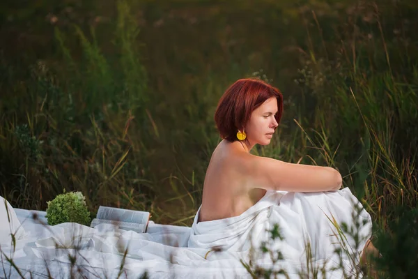 魅力的な白人女性30 35歳夏の日没時にフィールドに白いベッドに座って — ストック写真
