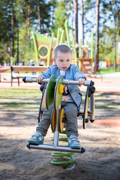 Caucasiano Menino Montando Balanço Playground Livre Dia Ensolarado — Fotografia de Stock