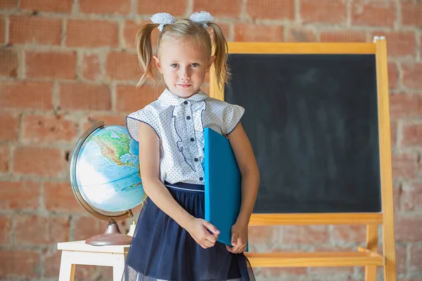 Unglückliches Kleines Mädchen Schuluniform Mit Einem Buch Der Hand Zurück — Stockfoto