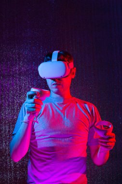 VR gözlüklü beyaz adam, sanal gerçeklikle video oyunları oynuyor.