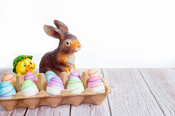 Renkli Boyanmış Paskalya Yumurtaları Beyaz Arka Plandaki Ahşap Masada Tavşanlı — Stok fotoğraf