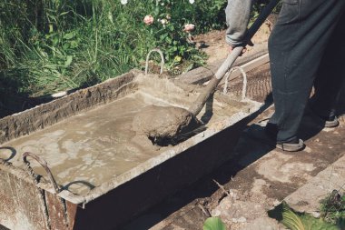 Bahçe yolunu doldurmak için çimento karıştırmak, bahçe inşaatı.