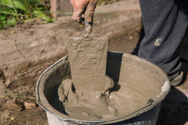 Bahçe yolunu doldurmak için çimento karıştırmak, bahçe inşaatı.
