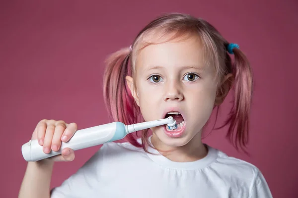 Χαμογελώντας Καυκάσιο Κοριτσάκι Καθαρίζει Δόντια Του Ηλεκτρική Ηχητική Οδοντόβουρτσα Ροζ — Φωτογραφία Αρχείου