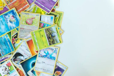 Florianopolis - Brazil, July 12, 2019: Pokemon cards distributed on the white table. Brazilian youths perform battles using these collectible cards clipart