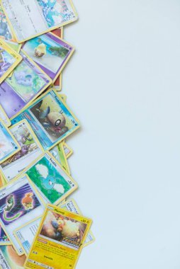 Florianopolis - Brazil, July 12, 2019: Pokemon cards distributed on the white table. Brazilian youths perform battles using these collectible cards clipart