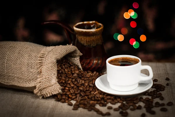 Чашка кави і кавових зерен на столі, натюрморт з ефектом боке — стокове фото