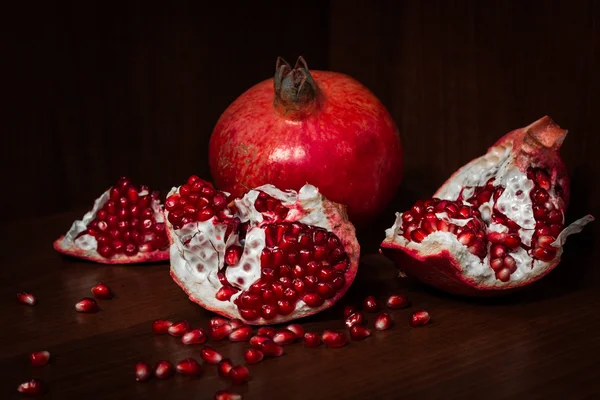 Pomegranate with broken segments, still life — Stock Photo, Image