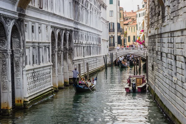 Venice, Italië - 27 juni 2014: Toeristen zeilen op gondels op water kanaal onder de brug der zuchten — Stockfoto