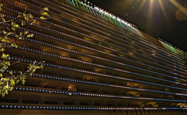 SOCHI, KRASNODAR KRAY, RUSSIA - ECTOBER 2020: Sochi şehrindeki Zhemchuzhina Oteli, bir medya cephesi ve karanlıkta parlayan ismin bir işareti ile binanın dış görünüşünün aydınlatıldığı gece..