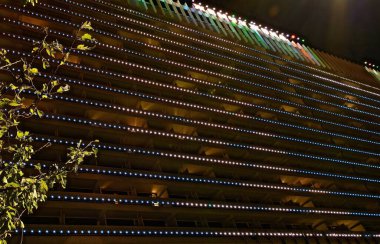 SOCHI, KRASNODAR KRAY, RUSSIA - ECTOBER 2020: Sochi şehrindeki Zhemchuzhina Oteli, bir medya cephesi ve karanlıkta parlayan ismin bir işareti ile binanın dış görünüşünün aydınlatıldığı gece..