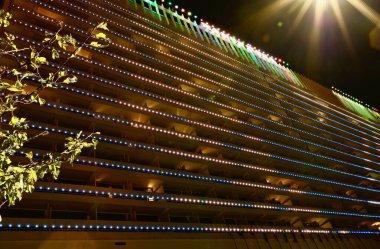 SOCHI, RUSSIA - Ekim 2020: Sochi 'nin merkezindeki otel binasının cephesinin gece aydınlanması karanlıkta parlıyor