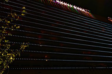 SOCHI, RUSSIA - Ekim 2020: Sochi 'nin merkezindeki otel binasının cephesinin gece aydınlanması karanlıkta parlıyor