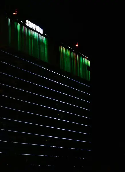 夜の街の暗闇の中で夜の電気照明で飾られたモダンな建物 — ストック写真
