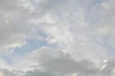 Açık mavi gökyüzü açık gri ve beyaz bulutlar yayılmış ışıkta