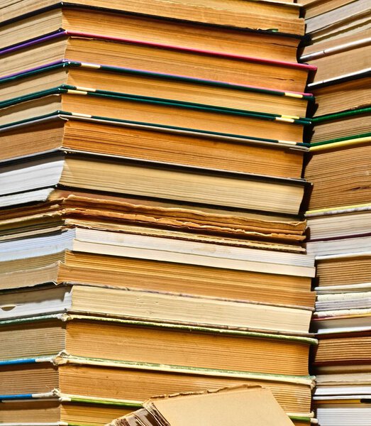 старое разнообразие книг, которые вращаются протиположными сторонами выстланы неровные стопки