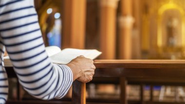 Halk kilisesinde kutsal İncil 'e dua eden Hristiyan bir kadın. Kadınlar, daha iyi bir hayat için Tanrı 'ya dua eder ve iyiliğe inanır..