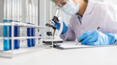 İlaç laboratuarında aşı geliştirme mikroskobuyla çalışan bir bilim adamı. Yenilik Konsepti.