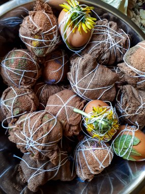 Ev yapımı geleneksel Paskalya yumurtası boyası. Farklı yapraklar, bitkiler ve çiçekler kullanarak. Marl yumurtaları soğan kabuğunda kaynatılmaya hazır.