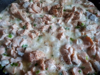 Makro somon filetosu. Küçük parçalar halinde kesilmiş. Zeytin yağı, yeşil soğan, biber ve ekşi krema ile sıcak tavada pişiyor.