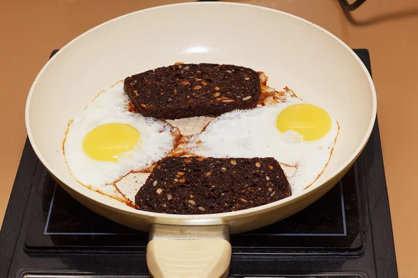 siyah ekmek dilimleri ile bir tavada kızarmış yumurta