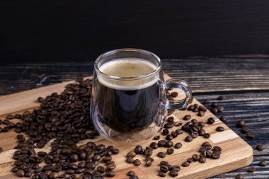 Tahtada kahve fincanı ve kahve çekirdeği.