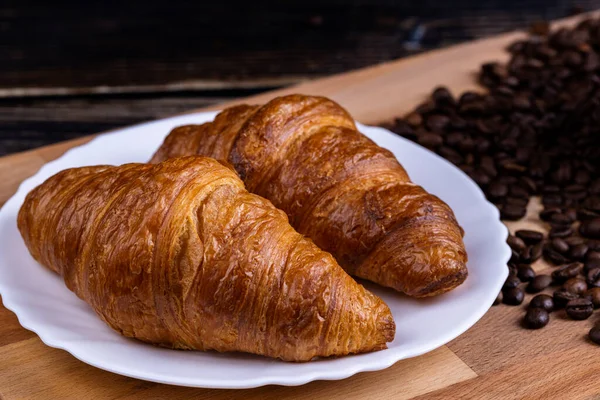 Croissants Sur Une Assiette Blanche Grains Café Sur Une Planche — Photo