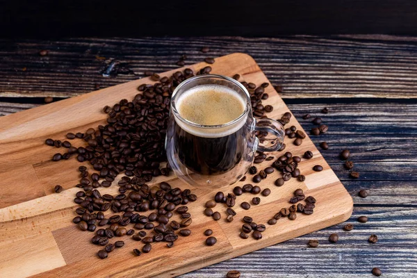 Coffee mug on wooden board and coffee beans