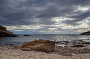 Sahilde önü kayalarla çevrili dağlar var. Fırtına dümeni